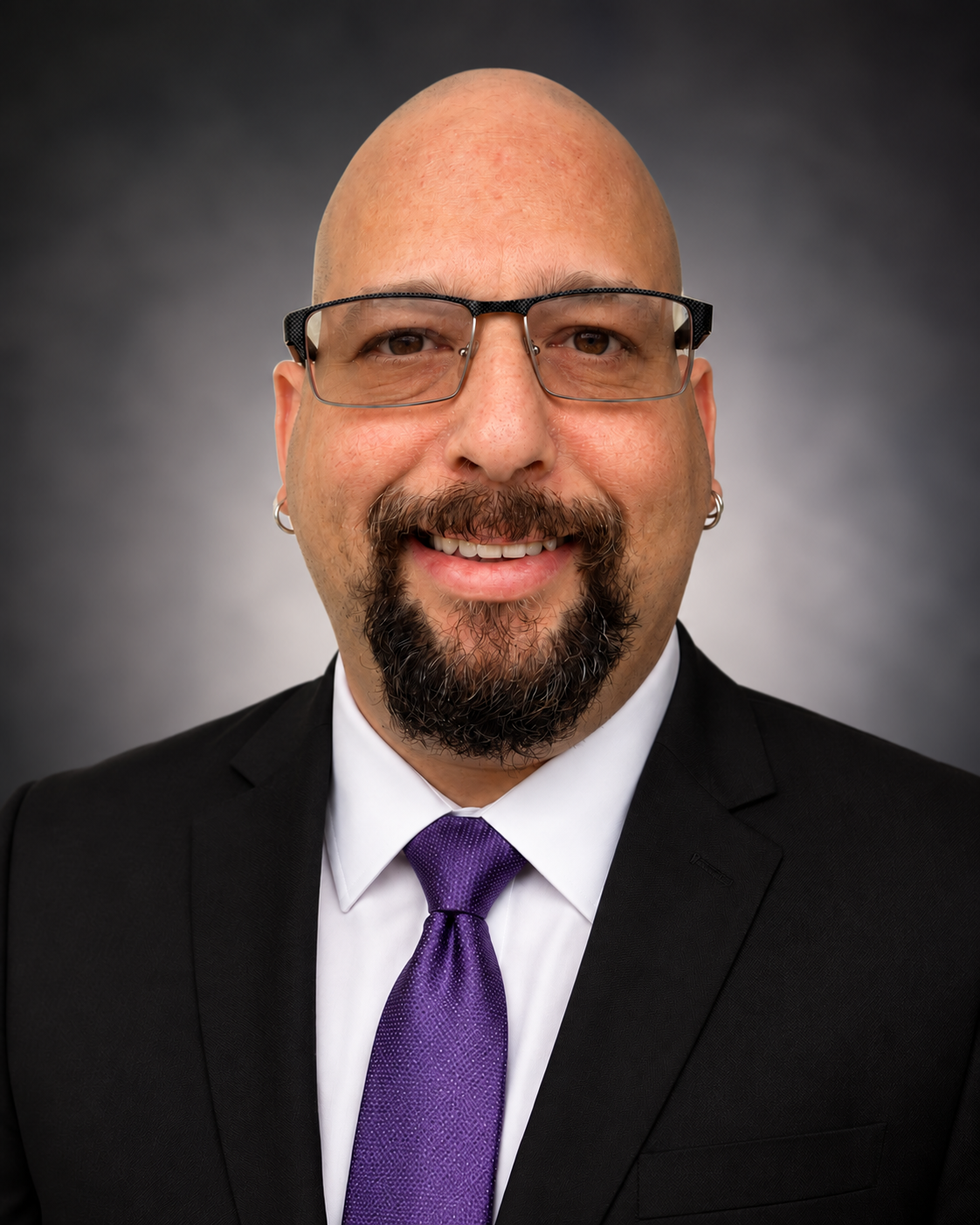 Seth Manning wearing a dark suit and purple tie